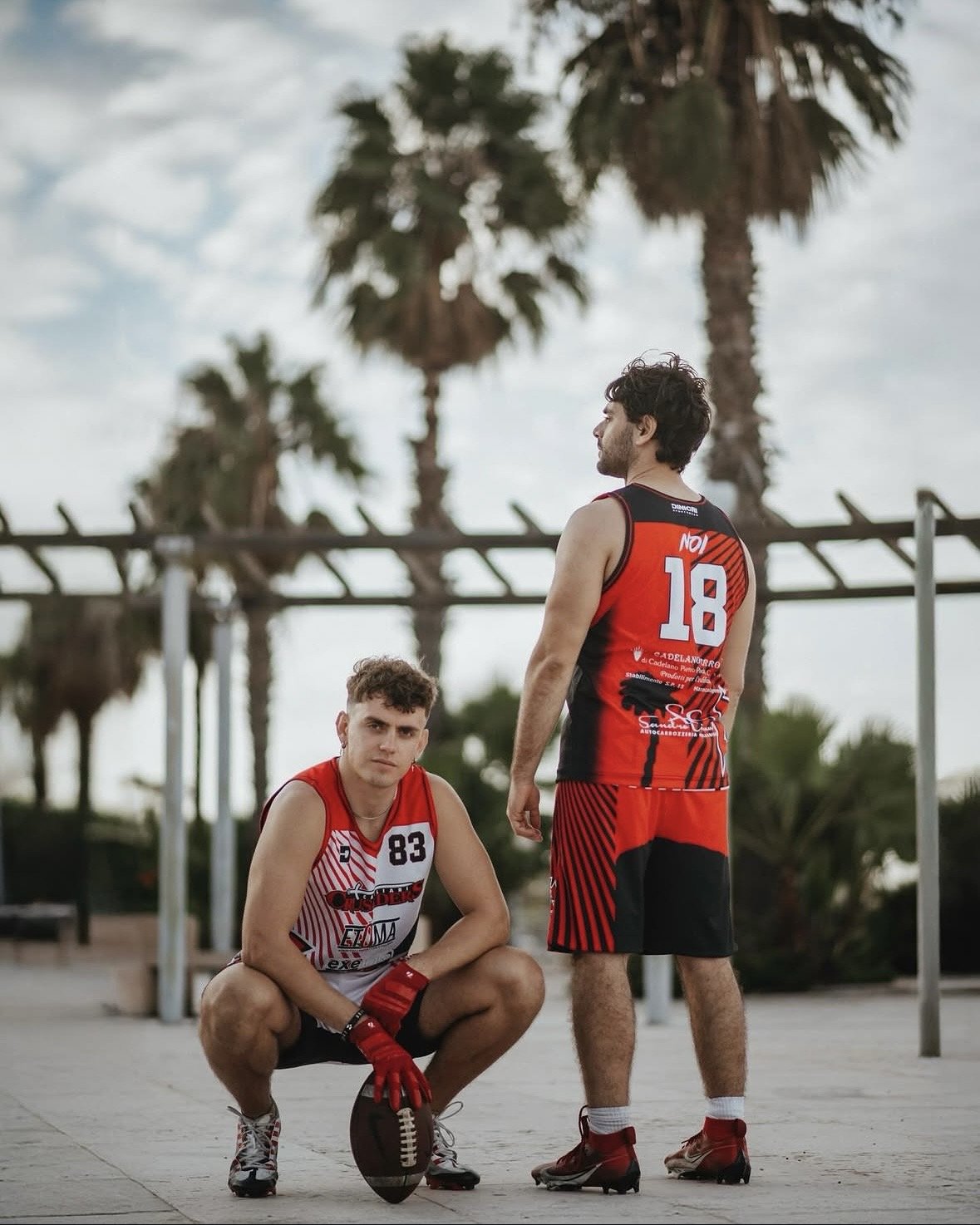 Due atleti con kit da football americano rossi e neri realizzati da Dinicri